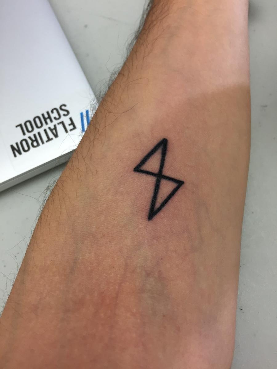 Learn.co logo tattoo on forearm