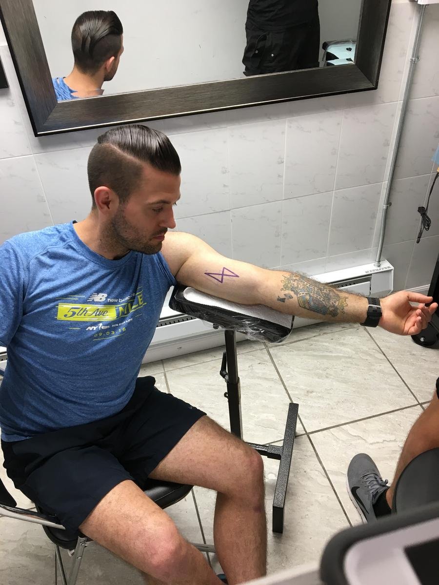 Student getting Learn.co tattoo at parlor