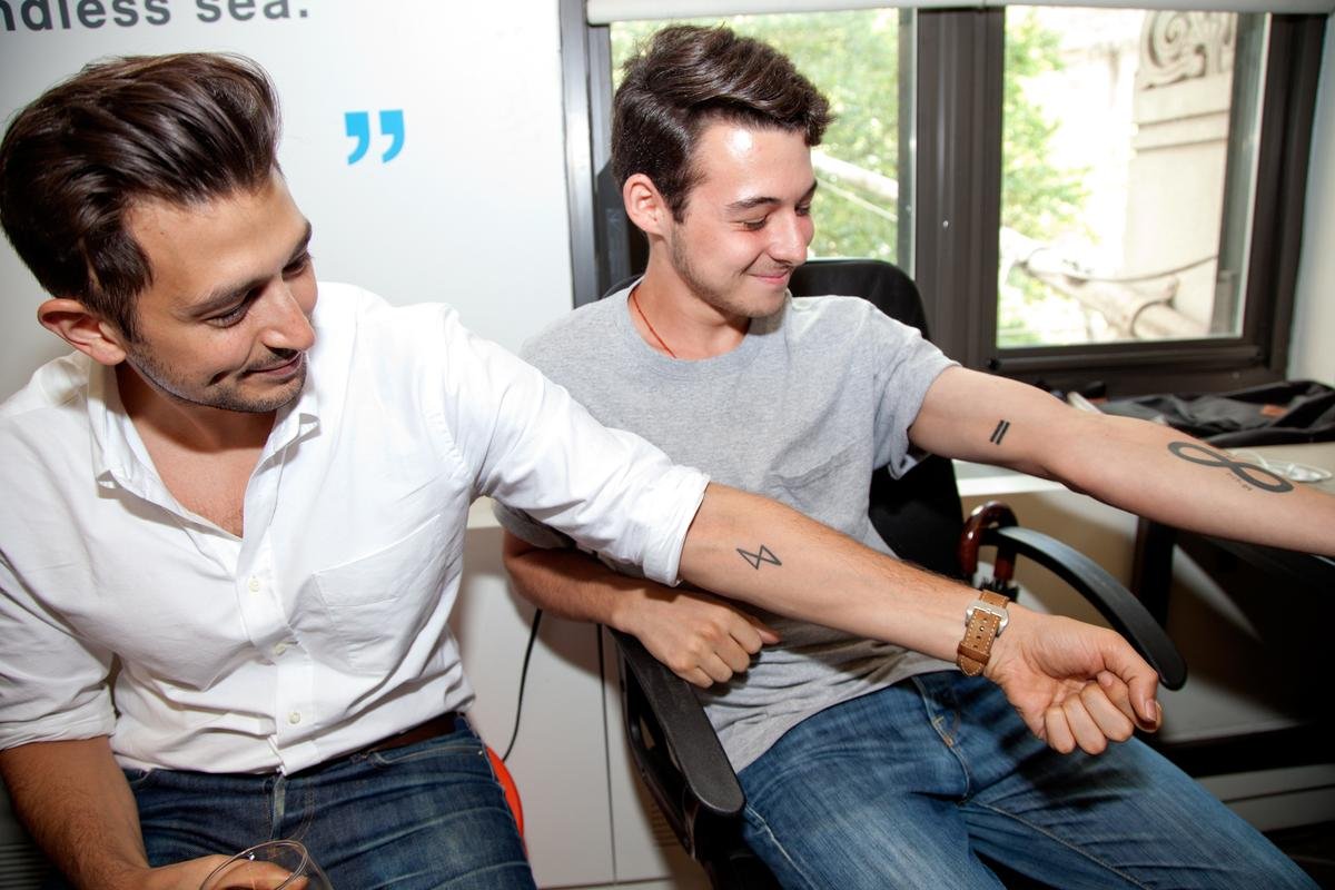 Avi Flombaum with a student showing off Learn.co tattoos